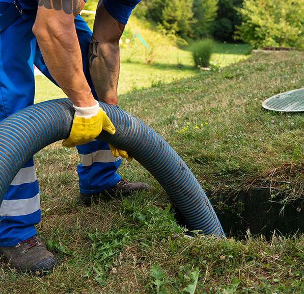 Worker handling septic service hose